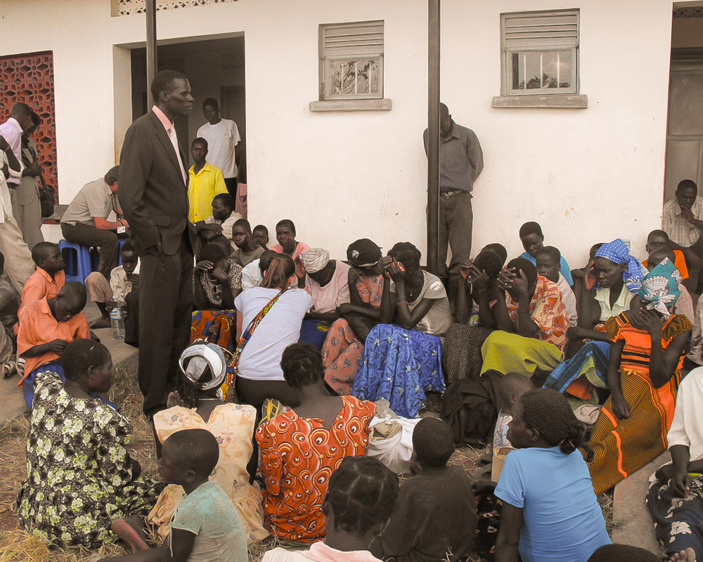 A group of Ugandans with Nodding Syndrome surround a local clinic waiting for it to open.